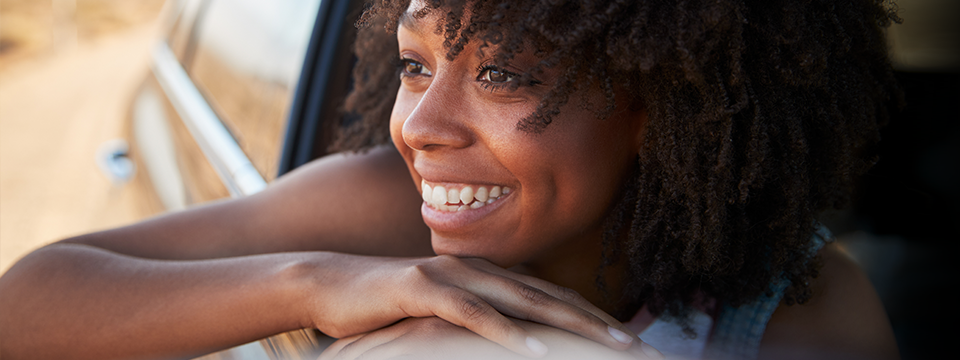 女人在电动汽车里微笑看着窗外